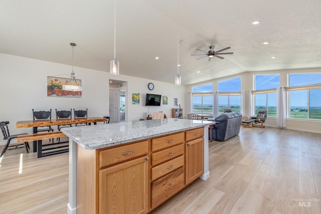 8142 US Highway 95, Marsing, ID 83639 - kitchen with light wood-style flooring, open floor plan, ceiling fan, lofted ceiling, and light stone counters