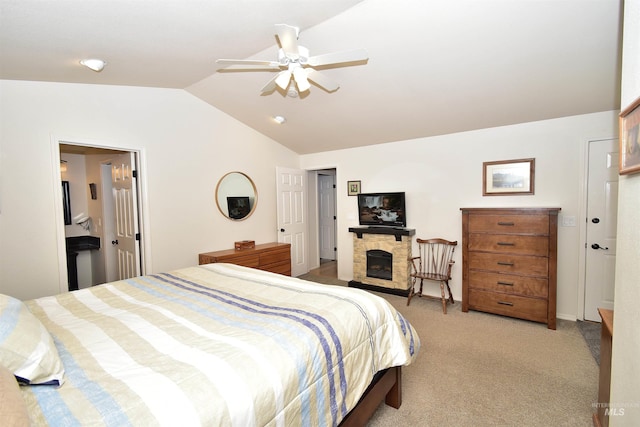 carpeted bedroom with vaulted ceiling, a fireplace, and ceiling fan