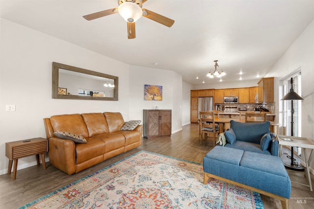 living room with dark hardwood / wood-style floors and ceiling fan with notable chandelier