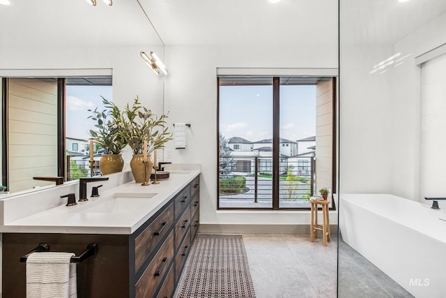 bathroom featuring tile patterned flooring, vanity, and a bath