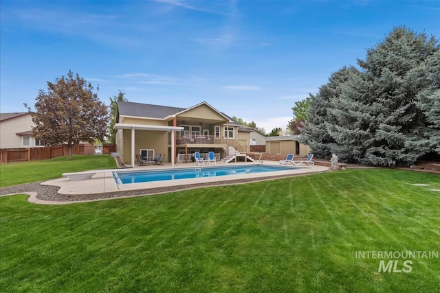 rear view of house featuring stairs, a storage shed, a fenced backyard, a fenced in pool, and a patio area