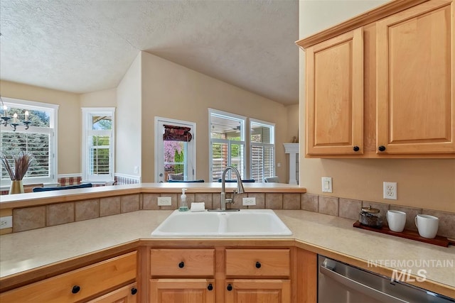 kitchen featuring stainless steel dishwasher, a sink, a textured ceiling, and light countertops
