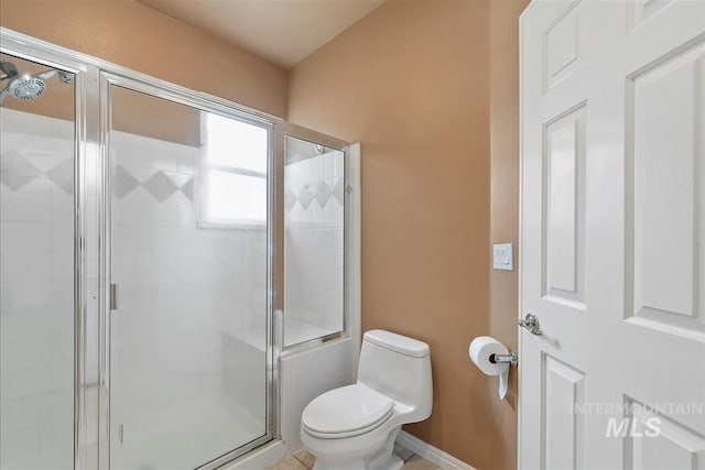 full bath with baseboards, a stall shower, and toilet