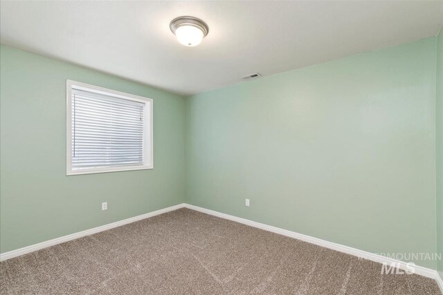 spare room with visible vents, baseboards, and carpet floors