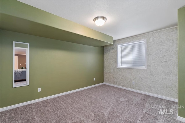carpeted empty room with baseboards
