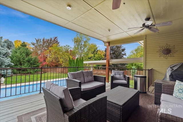 wooden terrace with a fenced in pool, a ceiling fan, and outdoor lounge area