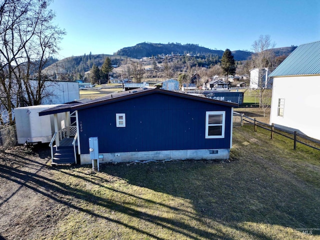 view of property exterior featuring a mountain view and a lawn