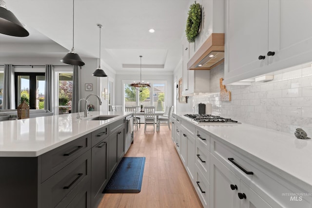 4337 W Ravenna St, Meridian, ID 83646 - kitchen featuring stainless steel appliances, a raised ceiling, light countertops, backsplash, and light wood-style floors