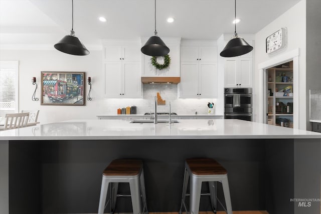 4337 W Ravenna St, Meridian, ID 83646 - kitchen with stainless steel double oven, decorative backsplash, light countertops, a large island, and white cabinets