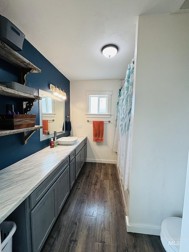 802 S 9th St, Rupert, ID 83350 - full bathroom with wood finished floors, vanity, baseboards, toilet, and curtained shower