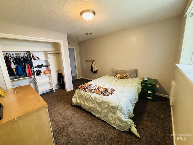 802 S 9th St, Rupert, ID 83350 - bedroom featuring dark carpet, a closet, a textured ceiling, and baseboards
