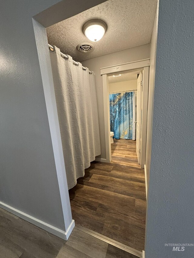 802 S 9th St, Rupert, ID 83350 - hall featuring wood finished floors, baseboards, a textured ceiling, and a textured wall