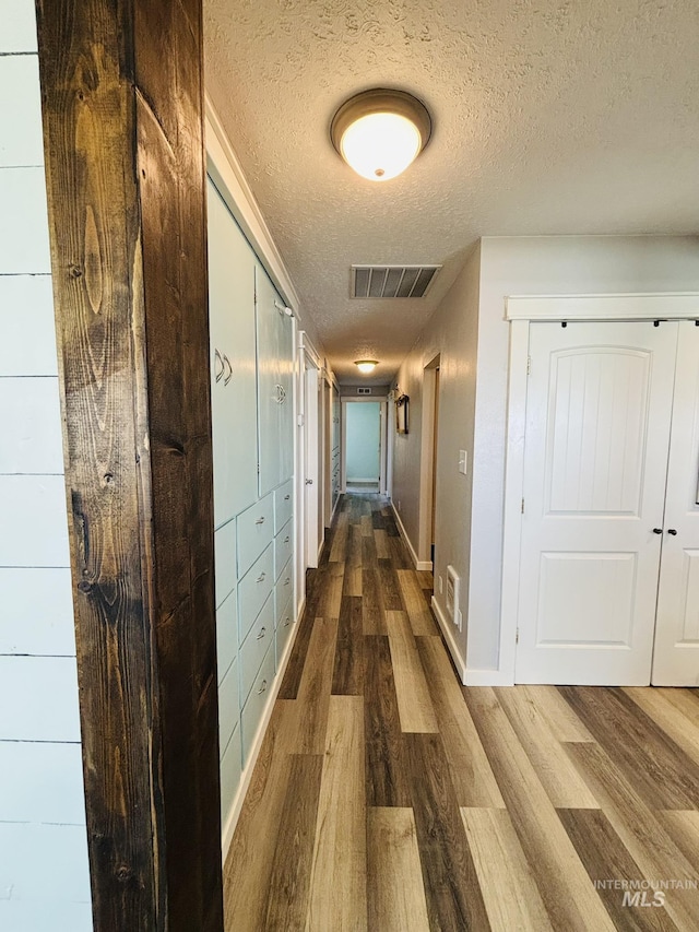 802 S 9th St, Rupert, ID 83350 - hallway with a textured ceiling, wood finished floors, and baseboards