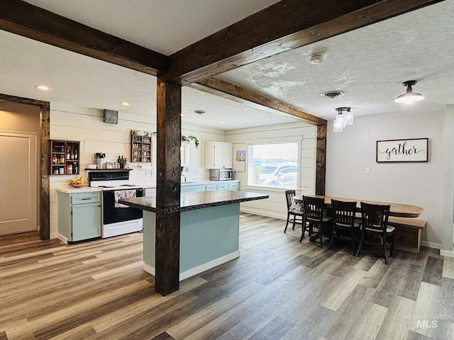 802 S 9th St, Rupert, ID 83350 - kitchen featuring white range with electric cooktop, light wood finished floors, stainless steel microwave, baseboards, and beam ceiling