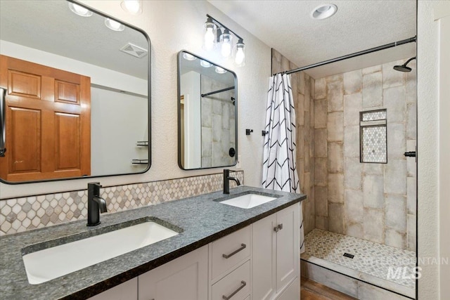 76 W Castle Creek Rd, Garden Valley, ID 83622 - bathroom featuring a tile shower, a textured ceiling, and double vanity