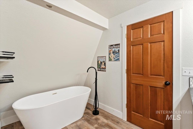 76 W Castle Creek Rd, Garden Valley, ID 83622 - full bathroom featuring a freestanding tub, baseboards, and wood finished floors
