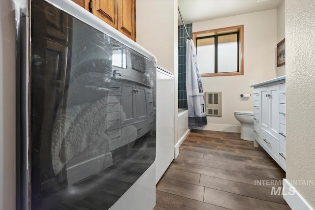 76 W Castle Creek Rd, Garden Valley, ID 83622 - bathroom featuring toilet, wood finished floors, shower / tub combo with curtain, heating unit, and baseboards