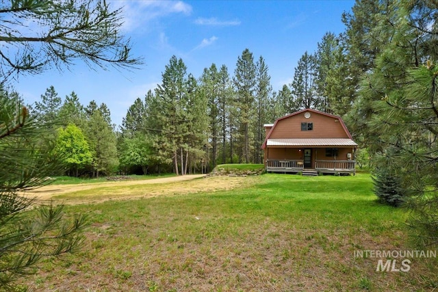 76 W Castle Creek Rd, Garden Valley, ID 83622 - view of green lawn featuring a porch and a forest view