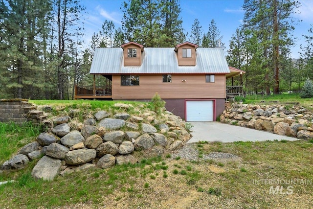 76 W Castle Creek Rd, Garden Valley, ID 83622 - view of property exterior featuring an attached garage, driveway, a deck, and metal roof