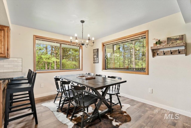 76 W Castle Creek Rd, Garden Valley, ID 83622 - dining room featuring a chandelier, baseboards, and wood finished floors