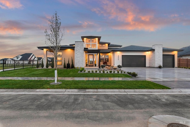 prairie-style house featuring a garage and a lawn