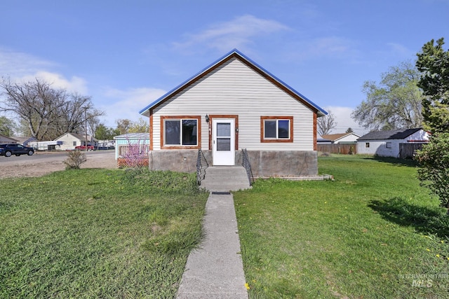 bungalow with a front lawn and fence