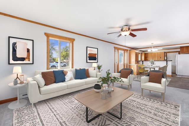 living room featuring ceiling fan with notable chandelier, baseboards, ornamental molding, and light colored carpet