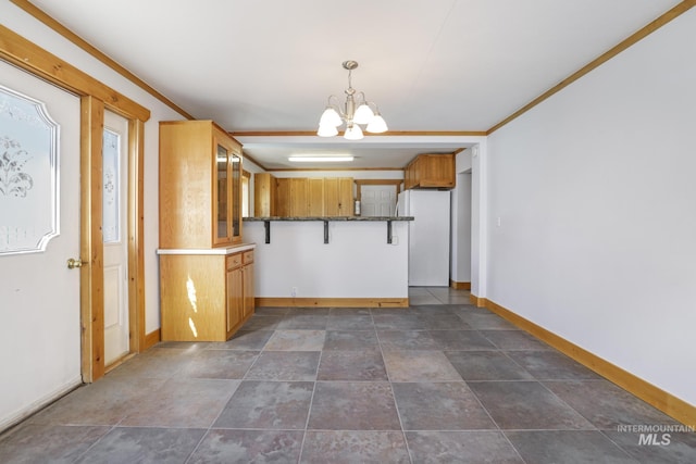 kitchen featuring baseboards, freestanding refrigerator, an inviting chandelier, and glass insert cabinets
