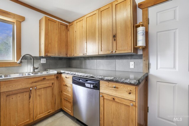 kitchen featuring stainless steel dishwasher, tasteful backsplash, and a sink