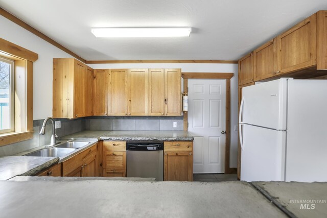kitchen featuring stainless steel dishwasher, a sink, decorative backsplash, light countertops, and freestanding refrigerator