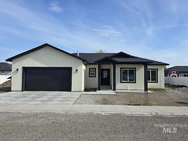 ranch-style home featuring an attached garage, stucco siding, and concrete driveway