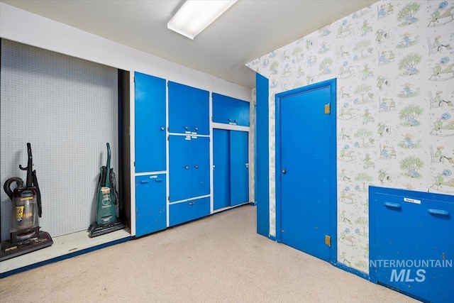 interior space with carpet and wallpapered walls