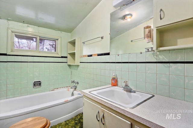 bathroom with a garden tub, tile walls, and vanity