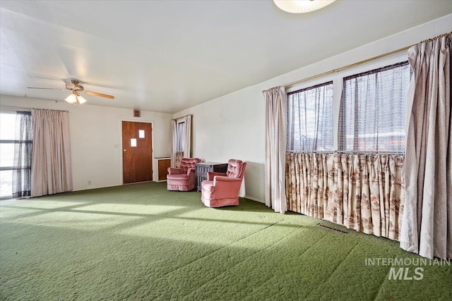 living area featuring carpet floors and ceiling fan