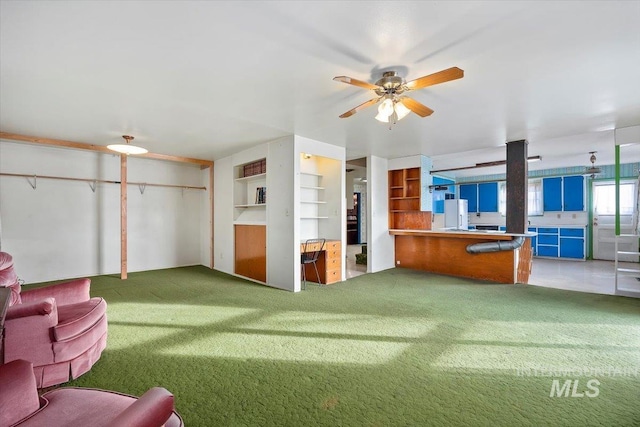 living area featuring carpet floors, ceiling fan, and built in shelves