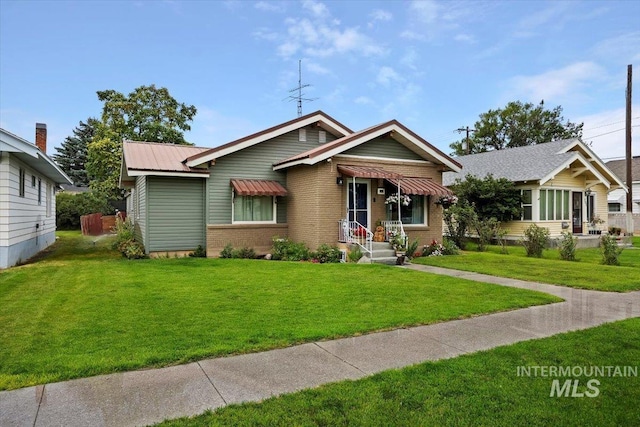 705 H St, Rupert, ID 83350 - view of front of property featuring metal roof, a front lawn, and brick siding