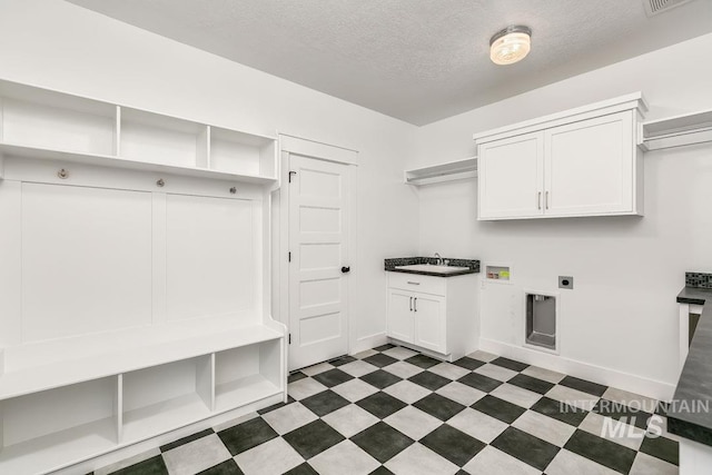 washroom featuring cabinets, hookup for an electric dryer, hookup for a washing machine, and a textured ceiling