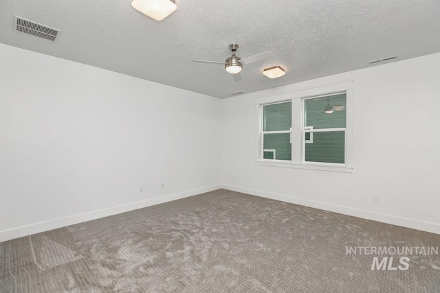 empty room with ceiling fan, a textured ceiling, and carpet flooring