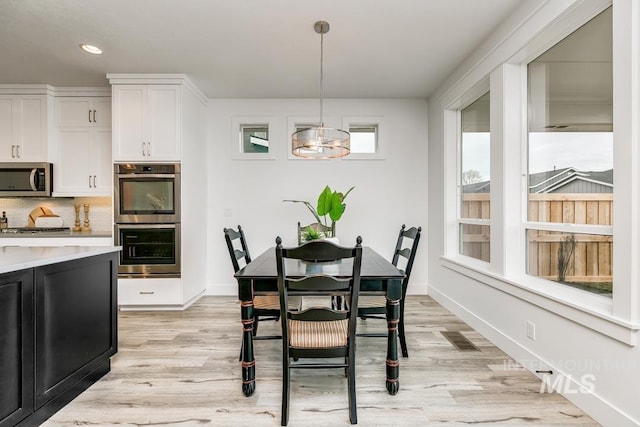 dining room with a notable chandelier and light hardwood / wood-style floors