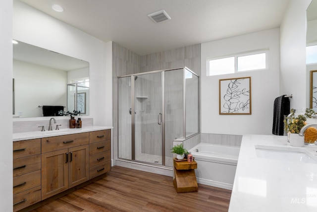 full bathroom with vanity, wood finished floors, visible vents, a stall shower, and a bath