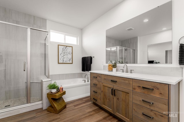 full bath with visible vents, a garden tub, wood finished floors, a shower stall, and vanity