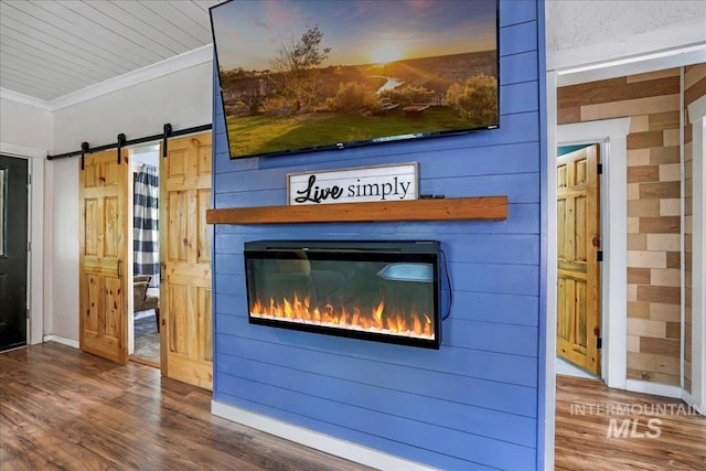 353 7th Ave E, Twin Falls, ID 83301 - detailed view of a barn door, ornamental molding, a glass covered fireplace, wood finished floors, and baseboards