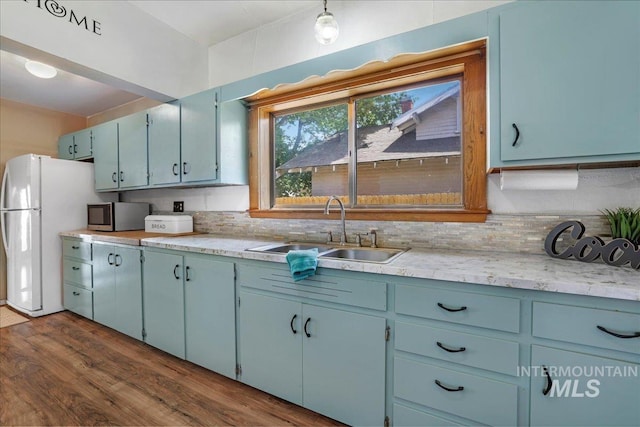 353 7th Ave E, Twin Falls, ID 83301 - kitchen featuring a sink, freestanding refrigerator, stainless steel microwave, dark wood-type flooring, and light countertops