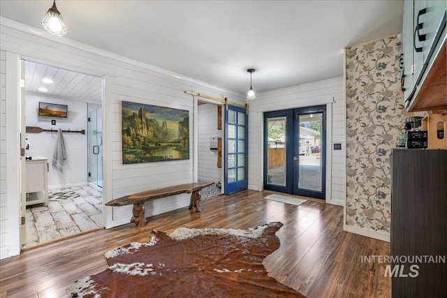 353 7th Ave E, Twin Falls, ID 83301 - entrance foyer featuring wood finished floors, a barn door, french doors, wood walls, and baseboards