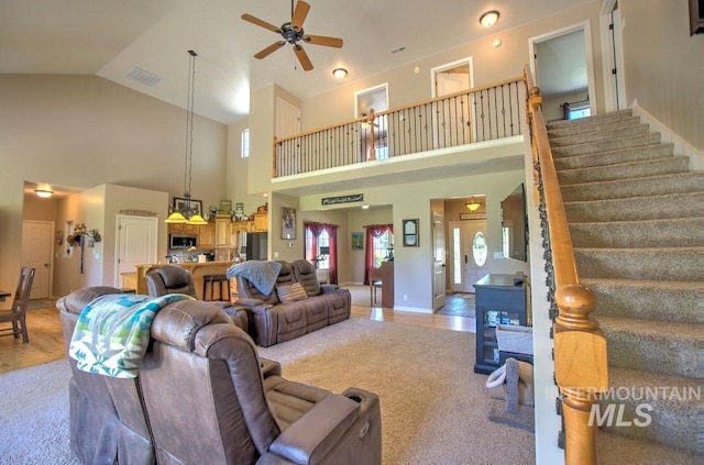 living room featuring ceiling fan, light hardwood / wood-style floors, and high vaulted ceiling