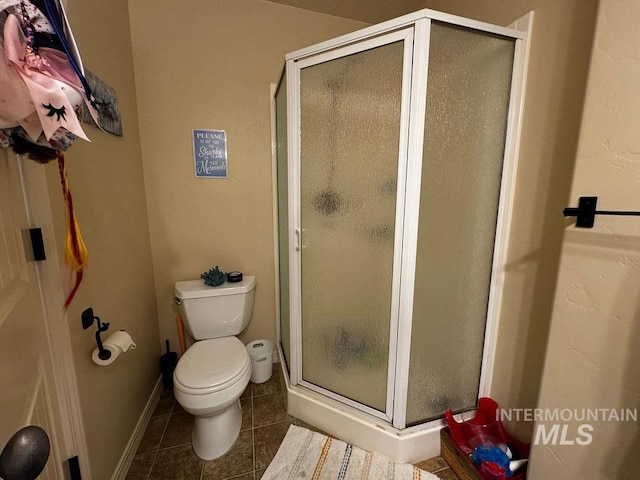 bathroom with walk in shower, tile patterned flooring, and toilet