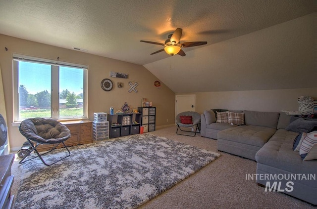 living room with a textured ceiling, lofted ceiling, ceiling fan, and carpet flooring