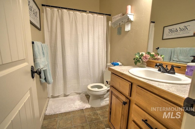 bathroom featuring tile patterned floors, toilet, walk in shower, and vanity