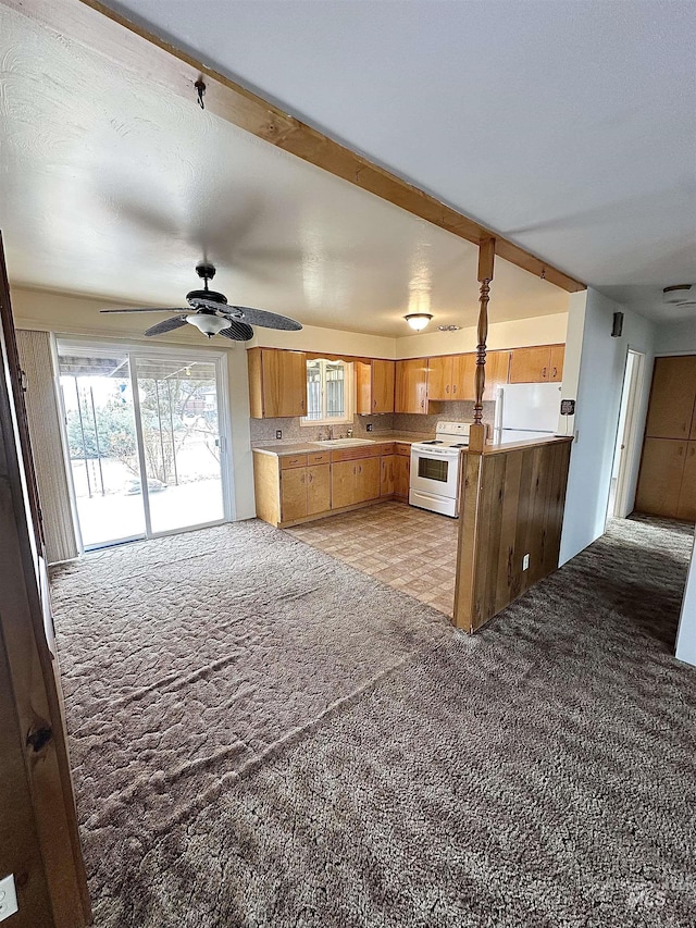 kitchen with sink, white appliances, tasteful backsplash, and light carpet