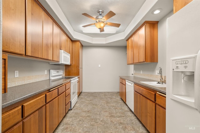 3017 Cypress St, Lewiston, ID 83501 - kitchen with white appliances, a sink, a tray ceiling, ceiling fan, and baseboards